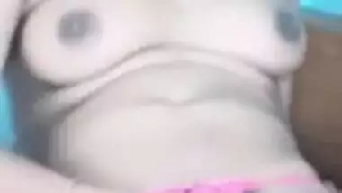 Female sits on bed exposing her XXX boobies and sex slit in Indian video